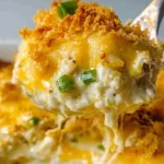 Plated serving of creamy Million Dollar Chicken Casserole with green onions.